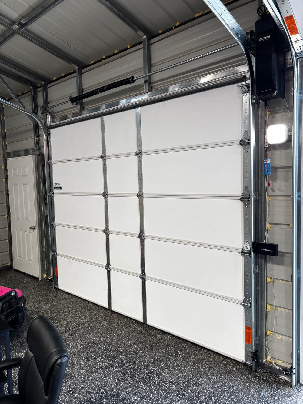 Modern garage interior featuring a white sectional garage door and organized space.