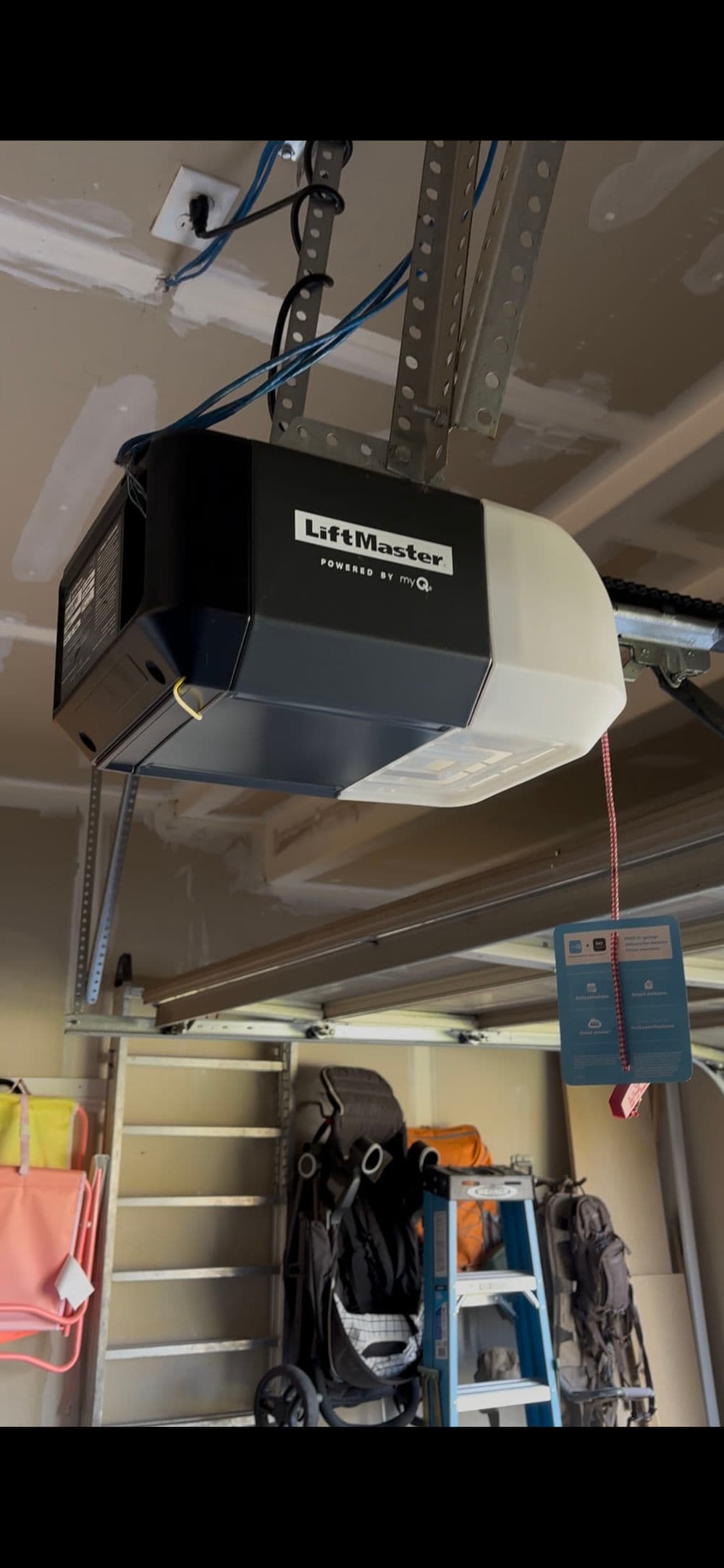 LiftMaster garage door opener mounted on ceiling with myQ technology and safety pull cord.