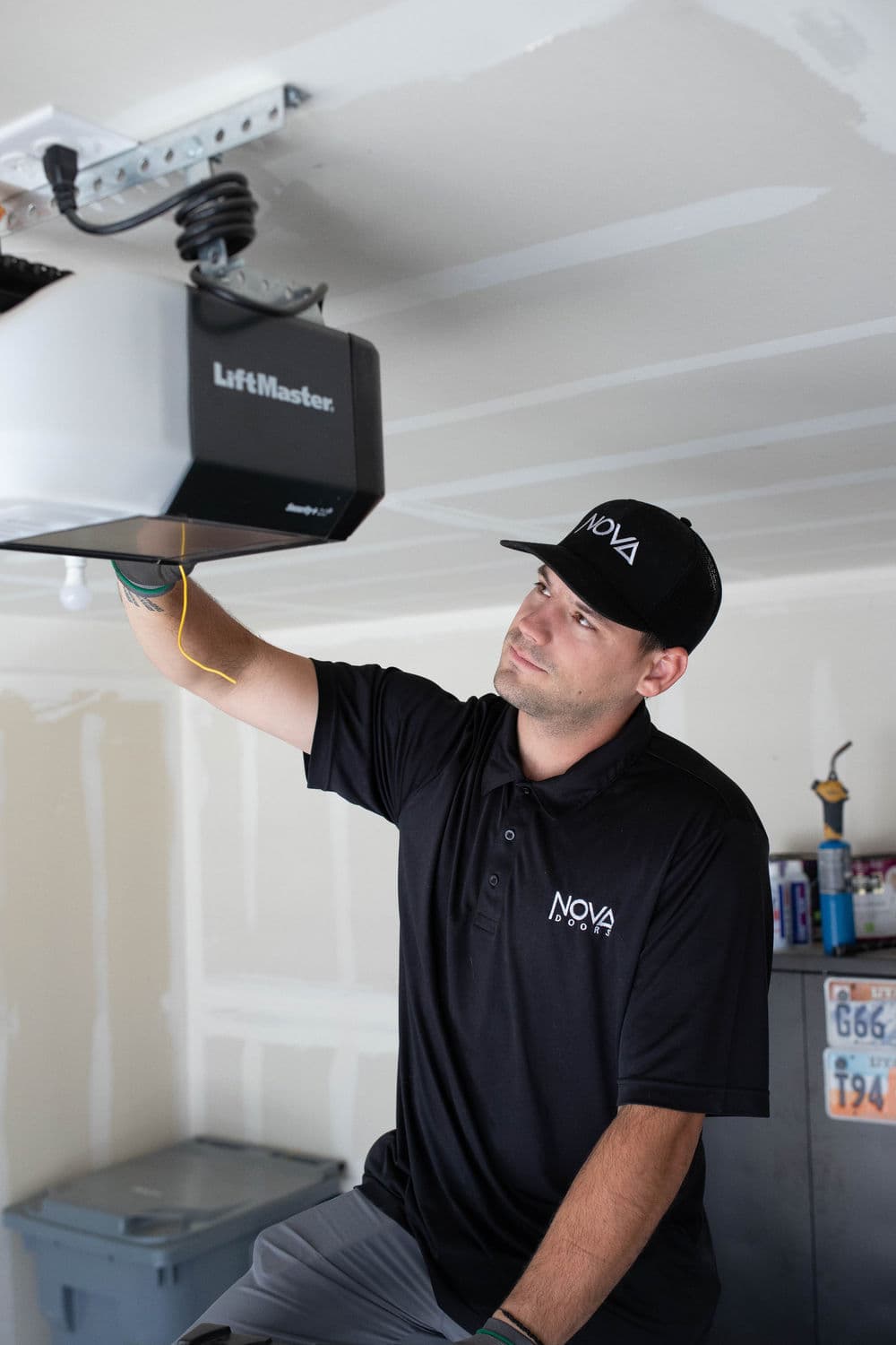 Technician inspecting LiftMaster garage door opener in a residential setting.